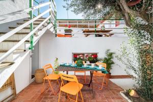 un patio con sillas naranjas, mesa y chimenea en CASA FLAMINGO, en Masnou