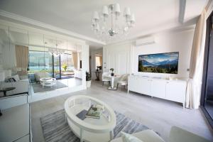 a living room with white furniture and a chandelier at Boutique Hotel Vissi d'Arte in Budva