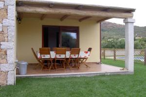 Una terraza de madera con una mesa y sillas. en VILLA ELEONORA-IUN-P6104, en San Teodoro