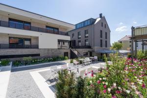 un patio con mesas, sillas y flores en Laurichhof, en Pirna