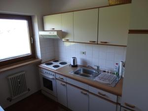 a kitchen with a sink and a stove and a window at Landhaus Sommerau in Reith bei Kitzbühel