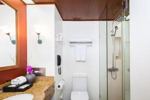 a bathroom with a shower and a toilet and a sink at Amari Don Muang Airport Bangkok in Bangkok