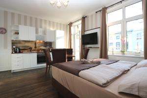 a bedroom with a bed and a kitchen with a table at Villa Ostseenordstern in Warnemünde