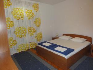 a small bedroom with a bed and a curtain at Apartmani Anka in Gradac