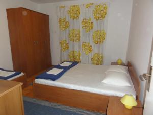 a small bedroom with a bed and a dresser at Apartmani Anka in Gradac