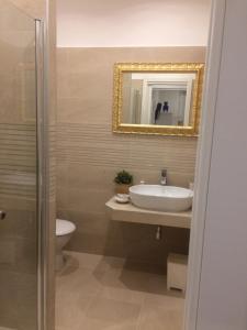 a bathroom with a sink and a toilet and a mirror at Nido all'Aventino in Rome