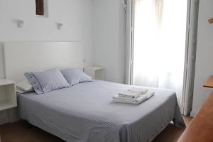 sypialnia z białym łóżkiem i ręcznikami w obiekcie Hostal La Zona w Madrycie