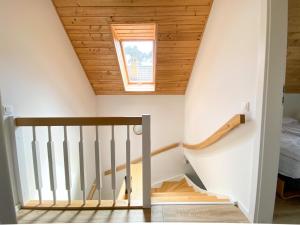 a staircase in a house with a wooden ceiling at Villa Złote Wydmy in Międzywodzie