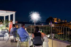 a group of people sitting on a balcony watching fireworks at Hotel Villa Durrueli Resort & Spa in Ischia +37 photos
