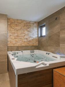 ein Bad mit einer großen Badewanne in einem Zimmer in der Unterkunft Penzion Dvojka in Velké Bílovice