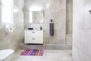 Baño blanco con lavabo y espejo en Kasa Katia Eco Guest House, en Valencia