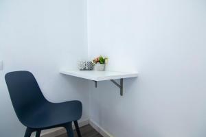 a white table and a blue chair in a room at Kasa Katia Eco Guest House in Valencia