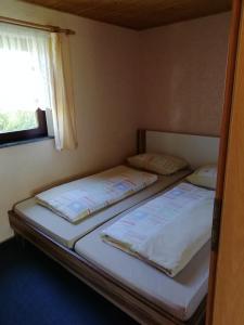 two beds in a small room with a window at Ferienhaus Möschwitz in Möschwitz