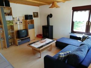a living room with a blue couch and a coffee table at Ferienhaus Möschwitz in Möschwitz