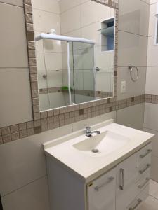 ein Badezimmer mit einem weißen Waschbecken und einem Spiegel in der Unterkunft CASA PÔR DO SOL 2 in Arraial do Cabo