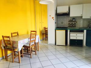 eine Küche mit einem Tisch und Stühlen sowie gelben Wänden in der Unterkunft Agenzia Isotur GINESTRA in Ponza