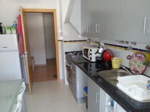 a kitchen with a sink and a stove top oven at Isis & Isa in Monte Gordo