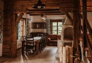 a kitchen and dining room with a table and chairs at Przystanek Ropienka Leśniczówka in Ropienka