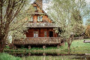 an old log cabin in the middle of a field at Przystanek Ropienka Leśniczówka in Ropienka