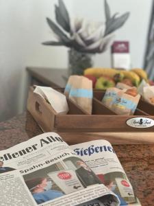a newspaper next to a box of food and a magazine at Residenz Hotel Giessen in Gießen