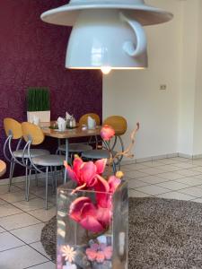 a dining room with a table and a vase with flowers at Residenz Hotel Giessen in Gießen