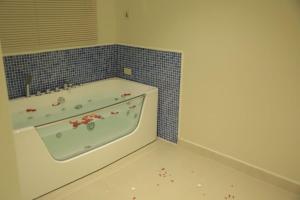 a bathroom with a tub with flowers on the floor at Amaken Aparthotel in Al Hofuf