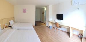 a hotel room with a bed and a desk with a tv at 7Days Inn Nanan Shuitou southeast Fortune Plaza in Quanzhou