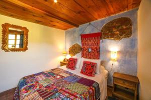 a bedroom with a bed with red pillows on it at Yellow House Hostel B&B in Antigua Guatemala