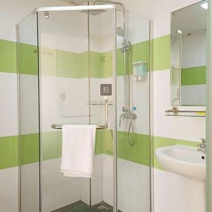 a bathroom with a glass shower and a sink at 7Days Inn Jinchang Culture Street in Jinchang