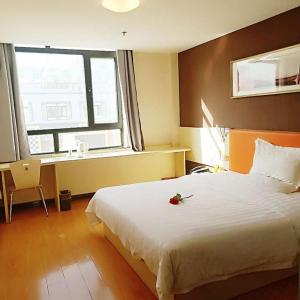 a bedroom with a large white bed and a window at 7Days Inn Jinchang Culture Street in Jinchang