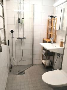 La salle de bains est pourvue d'une douche et d'un lavabo. dans l'établissement City Apartment Savonkatu, à Kuopio