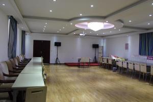 uma grande sala com mesas e cadeiras e um palco em 7Days Inn Bazhong International Trade City em Bazhong
