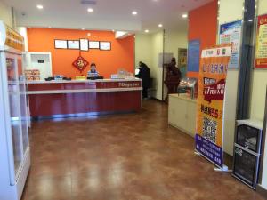a store lobby with a cash counter and orange walls at 7Days Inn Lintao city Gold street in Taoyang