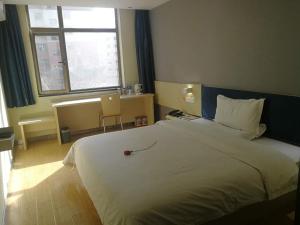 a bedroom with a large white bed and a window at 7Days Inn Lintao city Gold street in Taoyang
