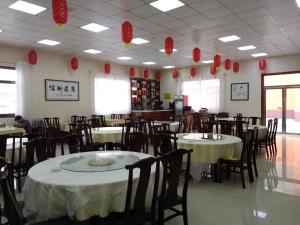 un restaurant avec des tables, des chaises et des lanternes en papier rouge dans l'établissement 7Days Inn Yulin Guangji building, à Yulin