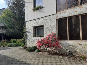 uma casa de tijolos com flores ao lado em Garsonka em Jílové u Prahy