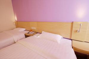um quarto de hotel com duas camas e um telefone em 7Days Inn ChengDu RenShou Shuyuan Road Haochi Street em Meishan