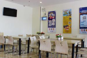 a dining room with tables and chairs and a flat screen tv at 7Days Inn Shaoguan Renhua Mount Danxia in Shaoguan