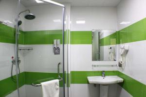 a green and white bathroom with a sink and shower at 7Days Inn Shaoguan Renhua Mount Danxia in Shaoguan