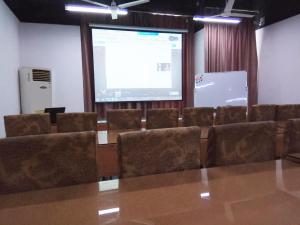 a conference room with a projection screen and chairs at 7Days Inn Suzhou Suzhou paradise Changjiang Road Su Fu Road in Suzhou