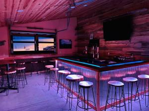 a bar with stools in a room with a tv at Black Elk Resort in Hill City