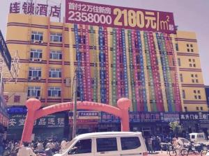 um edifício com um sinal em frente em 7Days Inn Hami Baofeng Market em Hami