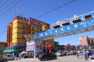 a city with a street with cars and buildings at 7Days Inn Hami Baofeng Market in Hami