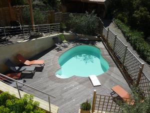 una piscina en una terraza con sillas alrededor en Le Mille Fleurs, en Aubres