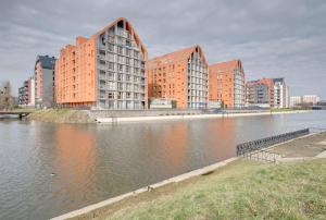 uma cidade com edifícios altos ao lado de um corpo de água em 3 City Apartments - Admiralski em Gdansk