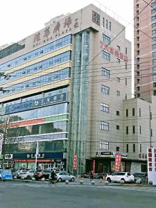 a large building with cars parked in front of it at 7Days Inn Shijiazhuang Friendship Avenue Jianguo Road in Shijiazhuang