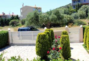 a gate in a garden with bushes and flowers at Helen's Sounio Apartments in Sounio