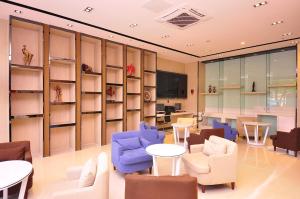 a room with chairs and tables and shelves at 7Days Premium Ji`nan Luokou Clothing City Wuying Hill North Road in Jinan