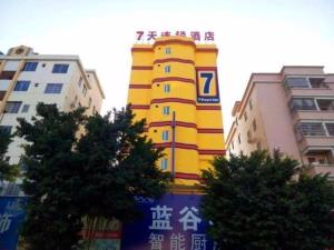 a yellow building in the middle of some buildings at 7Days Inn Sihui Middle Avenue in Zhaoqing