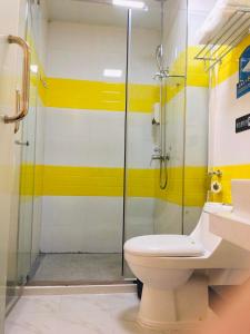 a bathroom with a toilet and a glass shower at 7Days Inn Sihui Middle Avenue in Zhaoqing
